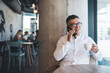 © BullRun - Positive man having conversation on smartphone in cafe