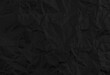 © nata777_7 - Black crumpled paper texture background.