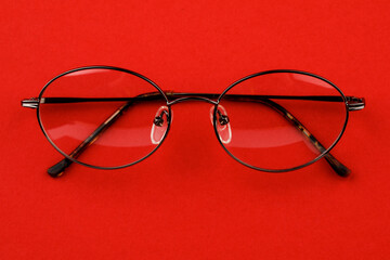 Classic glasses on a red background.