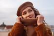 © Victoria Fox - Fashionable happy smiling woman wearing trendy beige beret, turtleneck sweater, brown faux fur coat, posing in European city. Copy, empty space for text