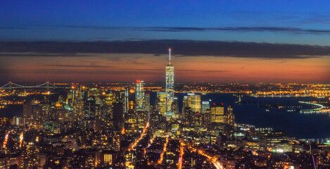  Breathtaking Panoramic and Aerial View of  Manhattan, New York City at Night. Illuminated Buildings After Sunset. Beautiful Crimson Colors in the Sky. Freedom Tower, Lady Liberty Statue, Hudson River.