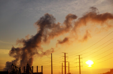 Wall Mural - Factory pipe polluting air at dusk, the thermal power plants with during sunrise