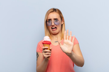 Wall Mural - young blonde woman feeling terrified, backing off and screaming in horror and panic, reacting to a nightmare