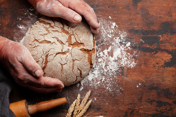 Wall Mural - Baker holding fresh baked homemade bread