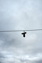 A Pair Of Shoes Hanging On A Wire