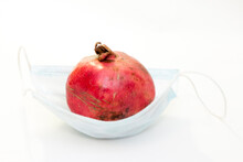 One Red Pomegranate Lies In A Protective Medical Mask