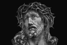 Jesus Christ In A Crown Of Thorns. Fragment Of An Ancient Statue Isolated On Black Background.
