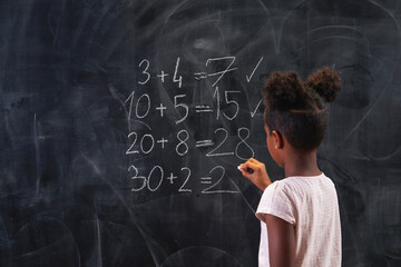 Schoolgirl practising summation on chalkboard