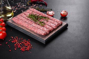 Fresh raw pork sausages with spices on a wooden cutting board