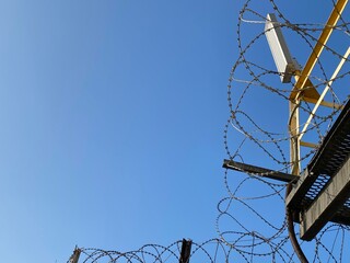 The barbed wire against the blue sky.