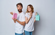 © SHOTPRIME STUDIO - man and woman with gift bags stand back to each other on gray background