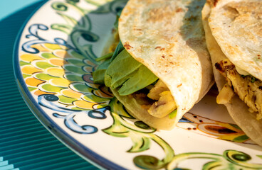 Canvas Print - Exquisite traditional quesadillas with chicken and spinach inside, on a plate on a blue table in close up concept.