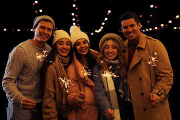 Poster - Group of people holding burning sparklers at night