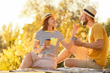 Sticker - Young couple eating sweet donuts and drinking coffee outdoors