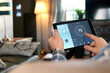 Man is Adjusting a temperature using a tablet with smart home app in modern living room