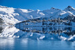 Glacier reflection in half frozen alpine lake. Beautiful blue Garibaldi lake in winter. Whistler. British Columbia. Canada. Room for captions. 
