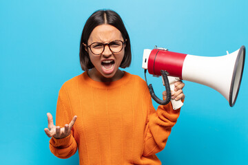 Wall Mural - young latin woman looking angry, annoyed and frustrated screaming wtf or what’s wrong with you