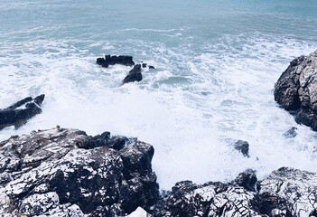 Splashing sea water, rocky coastline