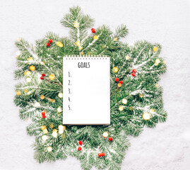 Wall Mural - Blank notebook for planning goals on New Year's green branches with lights