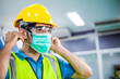 © winnievinzence - Portrait of male engineer worker wearing protective face mask, safety helmet and glasses at factory. industrial plant and new normal working. man standing and look forward, copy space
