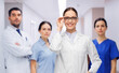© Syda Productions - medicine, vision and healthcare concept - happy smiling female doctor in glasses and white coat over colleagues at hospital on background