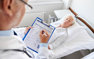 Poster - medicine, healthcare and people concept - senior woman and doctor writing to clipboard at hospital ward