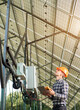 © anatoliy_gleb - Engineer checking the operation of solar power station. Woker in helmet and with laptop and sensor in his hands, looking up. Science technology. Global warming. Green energy.