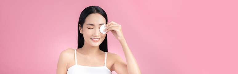 Wall Mural - Asian Woman using cotton pad. Happy smiling beautiful young woman cleaning skin by cotton pad.