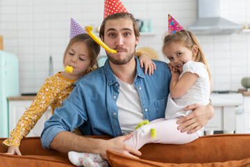 Wall Mural - Birthday party. Family Celebrating daughter's Birthday, having fun at party, wearing birthday hats.