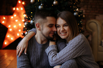 Wall Mural - lovers are sitting under a christmas tree with gifts