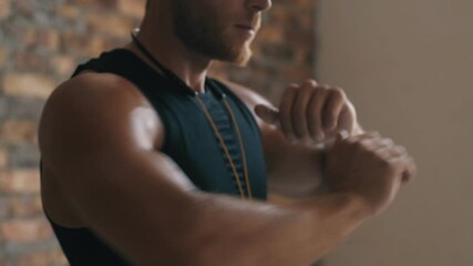 Wall Mural - A cropped-view of a muscular man is training standing isolated over a brick wall