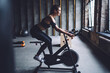 © BullRun - Content sportswoman exercising on cycling machine
