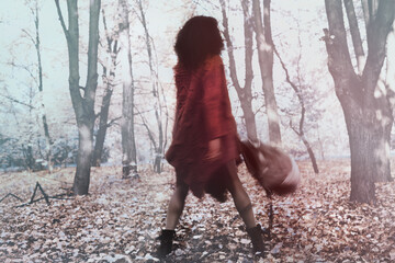 Wall Mural - Young black woman relaxing in the autumn forest on a sunny day.