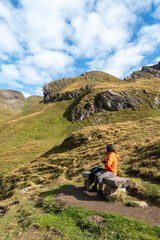 woman sitting on bench in the middle of hiking trail on the moutains