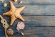 Sea and ocean gifts on a wooden background. Marine things. Sea products. Water Background for real man captains and sailors. Pirate design. Bottle, rope, star. Underwater treasures.