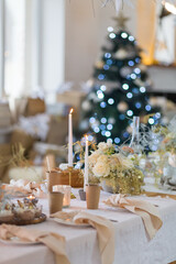 Christmas decoration of the festive table on the background of a Christmas tree with Christmas decorations