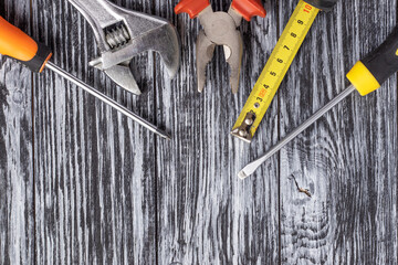 Wall Mural - Set of tools on a black wooden background. Top view.