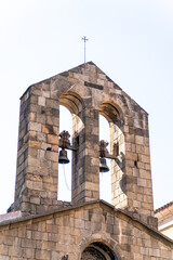 Old white spanish catholic church with rooftop and churchbell in Barcelona