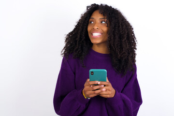 Copyspace photo of Young beautiful African American woman wearing knitted sweater against white wall stupor with something occurring in social media