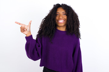 Wall Mural - Young beautiful African American woman wearing knitted sweater against white wall pointing up with fingers number eight in Chinese sign language BÄ.