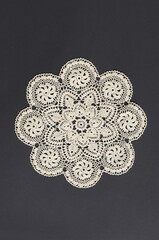 Lace doily on a black background.