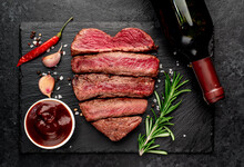 Different Degrees Of Roasting Heart-shaped Beef Steak With Spices And Bottle Of Wine On A Stone Background. Valentines Day Celebration Concept