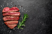 Different Degrees Of Roasting Beef Steak In Heart Shape With Spices On A Stone Background With A Copy Of The Space For Your Text.