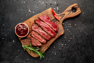 Wall Mural - Different degrees of roasting beef steak in heart shape with spices on a stone background