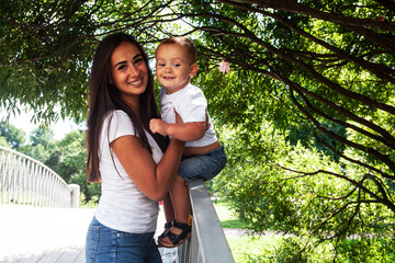 young pretty brunette mother with little cute boy walking in park happy smiling, lifestyle people concept