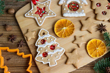  Christmas homemade cookies with spices, dried oranges on wooden table.