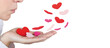 © Graphic PhotoArt - Beautiful woman blows many hearts of cloth from the palm of her hand and they fly away as a concept of love and friendship on Valentines Day. Concept of heart health and organ donation. Copy space