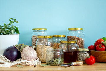 Zero waste healthy food-cereals, seeds, vegetables flat lay on grey background. Groceries in textile bags,glass jars, wooden bowl. Eco friendly plastic free low waste lifestyle.