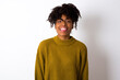 © Jihan - Young beautiful African American woman wearing knitted sweater against white wall with happy and funny face smiling and showing tongue.