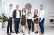 © Elizaveta - Smiling employees standing looking camera making team picture in office together. Business People Team. Successful company with happy workers. People Meeting Communication Corporate Teamwork Concept